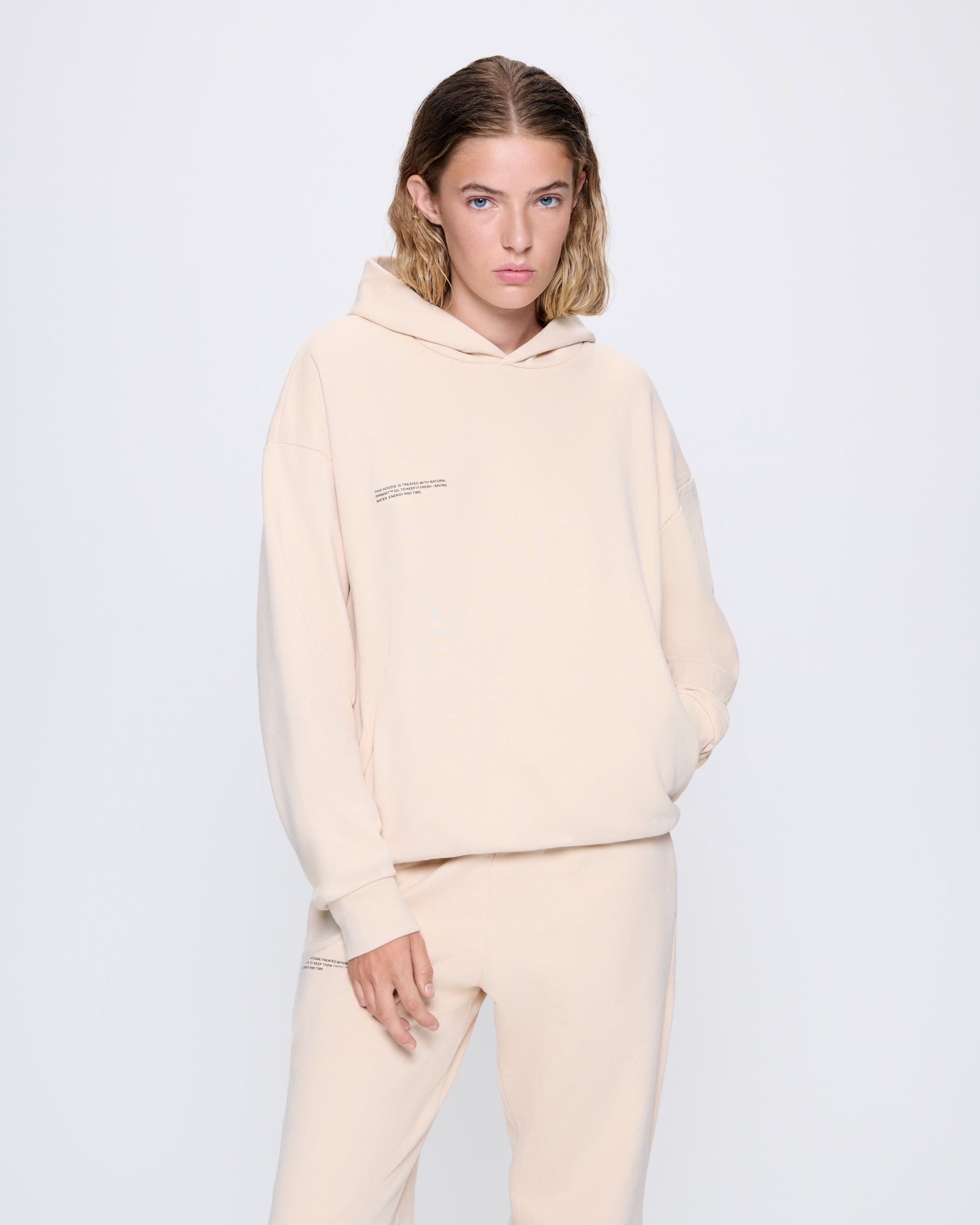 365_MIDWEIGHT_HOODIE_SAND_WOMENS_FRONT-MODEL