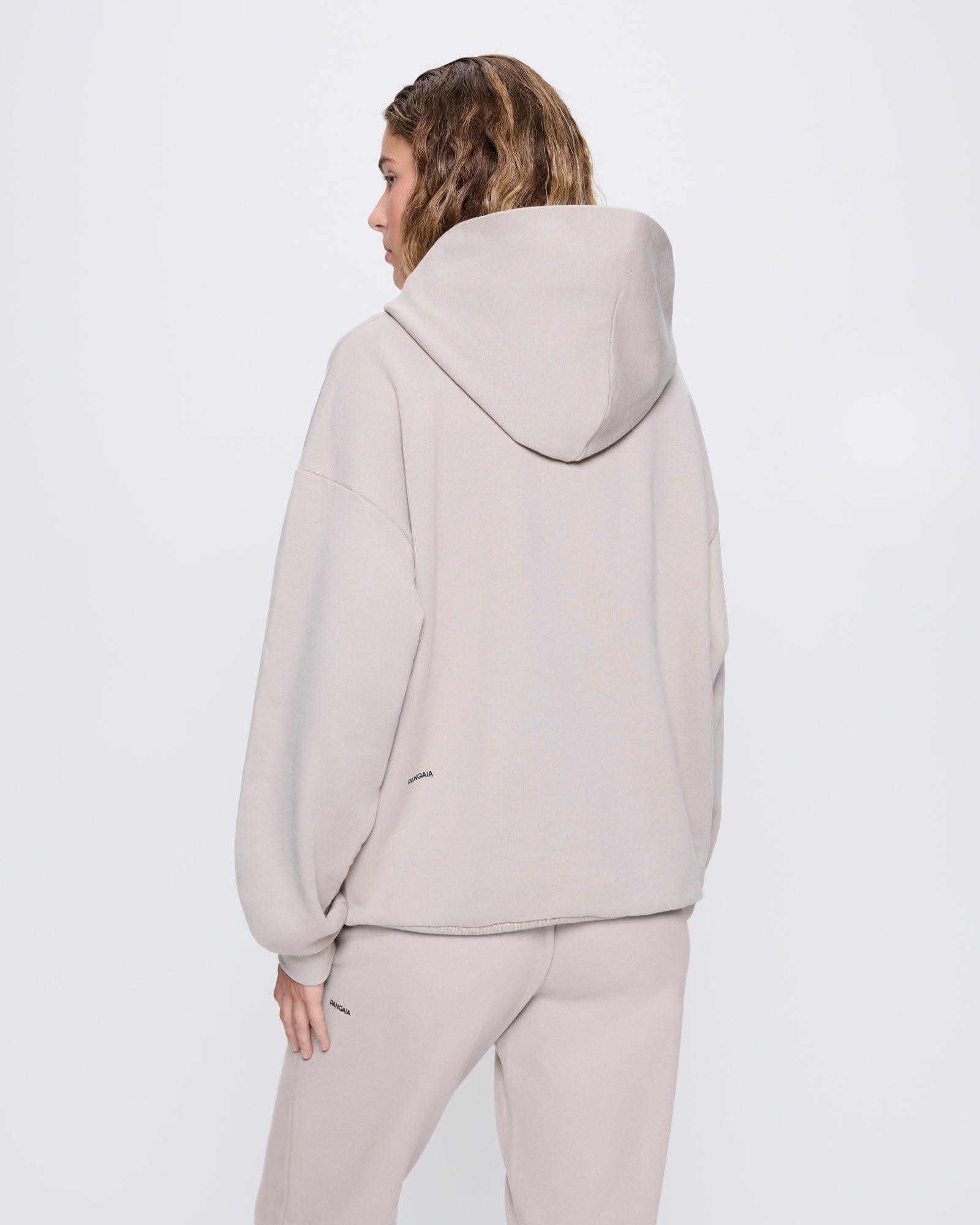 365_MIDWEIGHT_HOODIE_STONE_WOMENS_BACK_71010ab9-844d-4e71-93a3-3ab1742a367a-MODEL