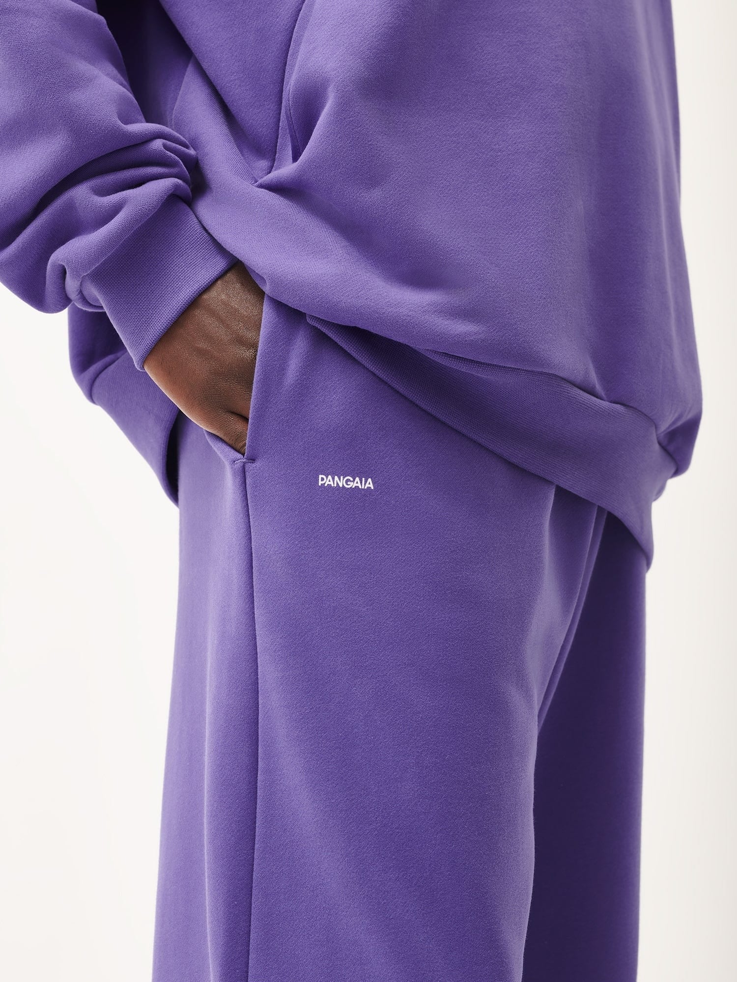 Pangaia violet purple cotton fleece loungewear set, relaxed fit sweatshirt, matching joggers, model's hand in pocket