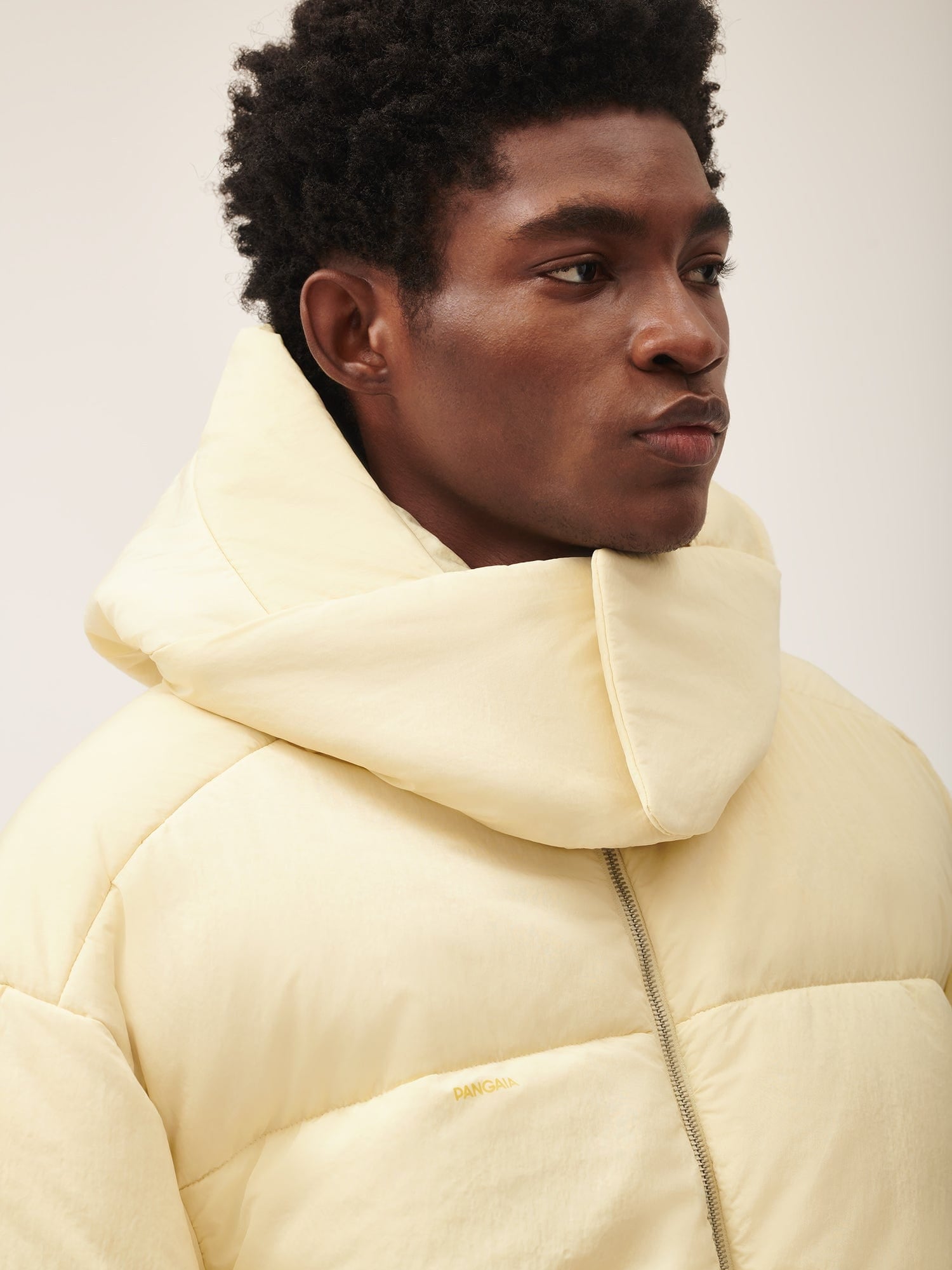Pale yellow PANGAIA men's oversized puffer jacket with voluminous padded collar and front zipper Premium winter outerwear
