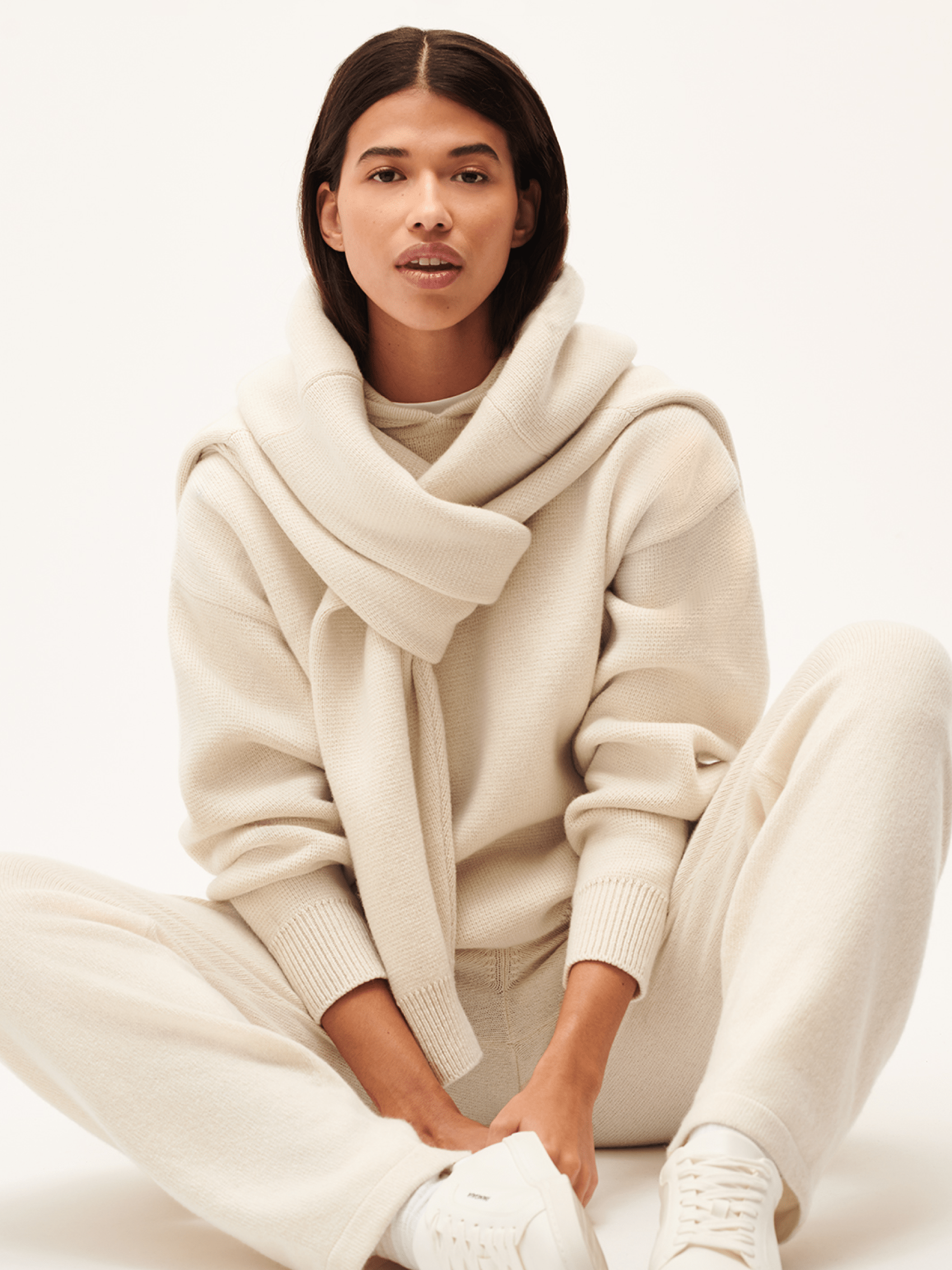 Cream waffle knit sweater, matching relaxed knit pants, and draped cowl neck on woman, premium loungewear set