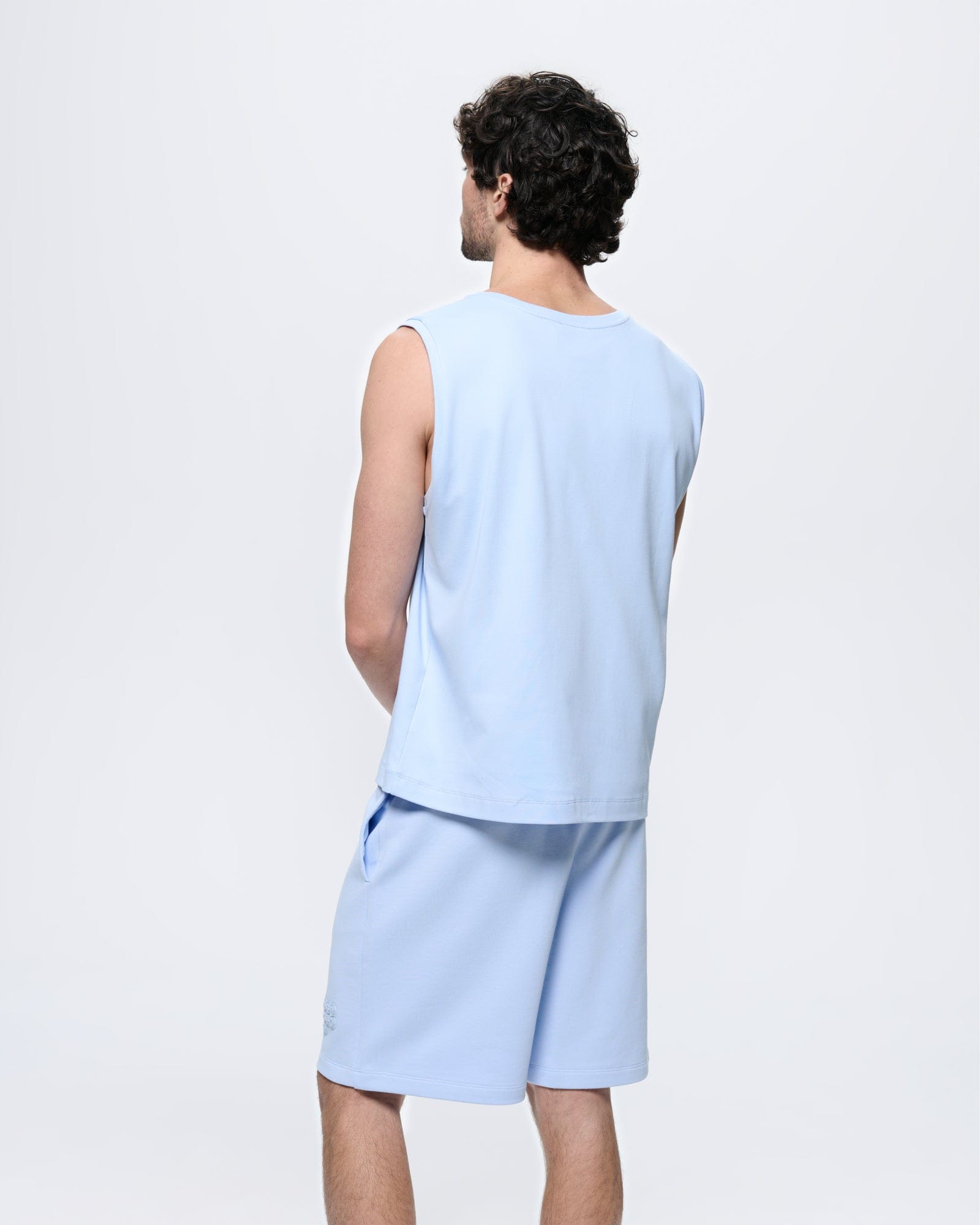 Mens Wildflower Blue 100% organic cotton sleeveless t-shirt, relaxed fit, crew neck. Model from back in matching shorts