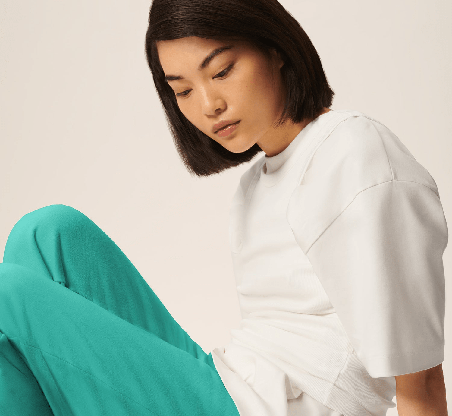 Premium white oversized short-sleeve tee with ribbed crew neck and vibrant teal fluid relaxed fit trousers on model
