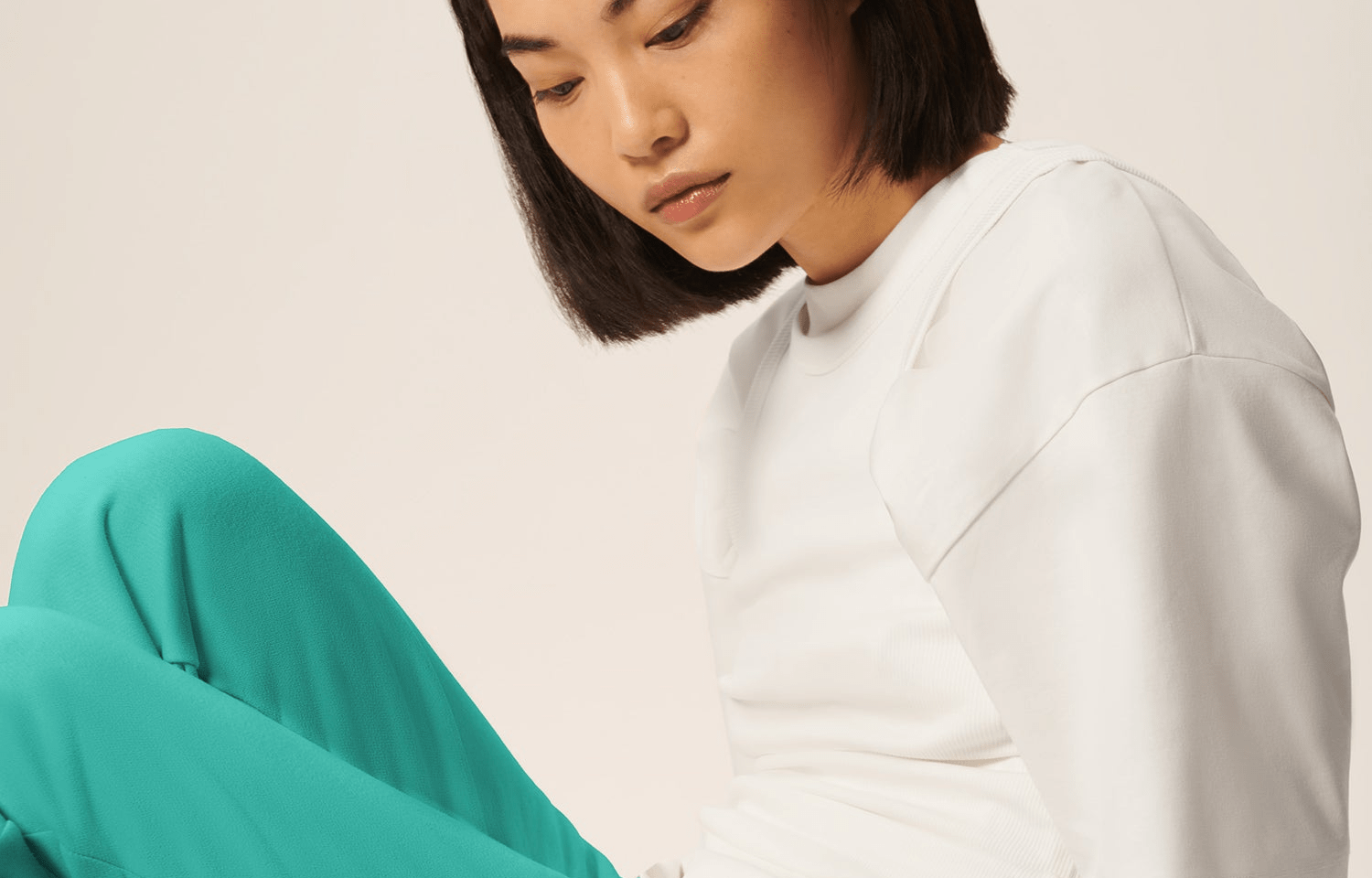 Premium white oversized short-sleeve tee with ribbed crew neck and vibrant teal fluid relaxed fit trousers on model