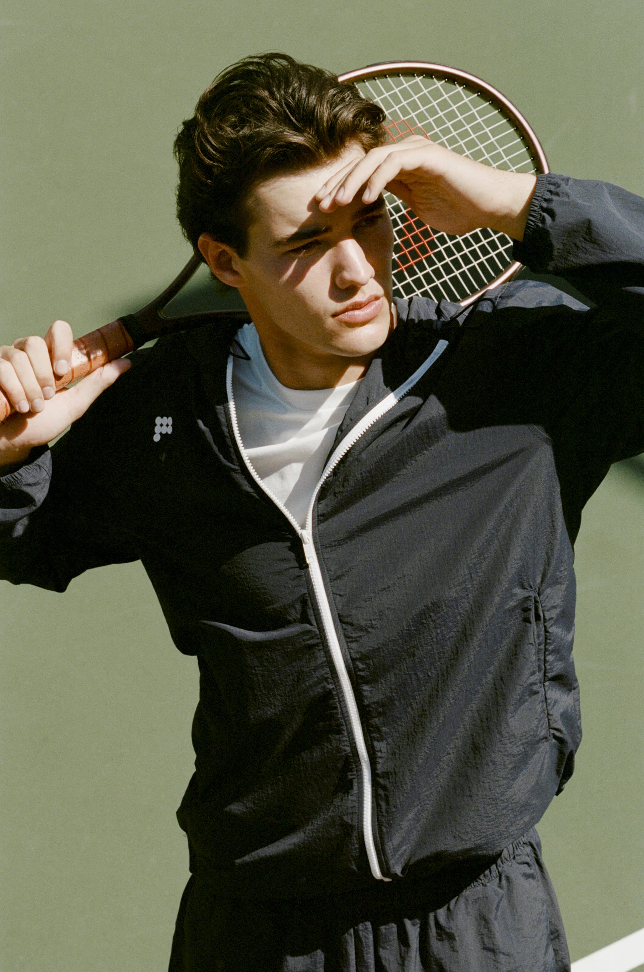Men's dark navy crinkle nylon full-zip jacket with white zipper, logo, and matching athletic shorts