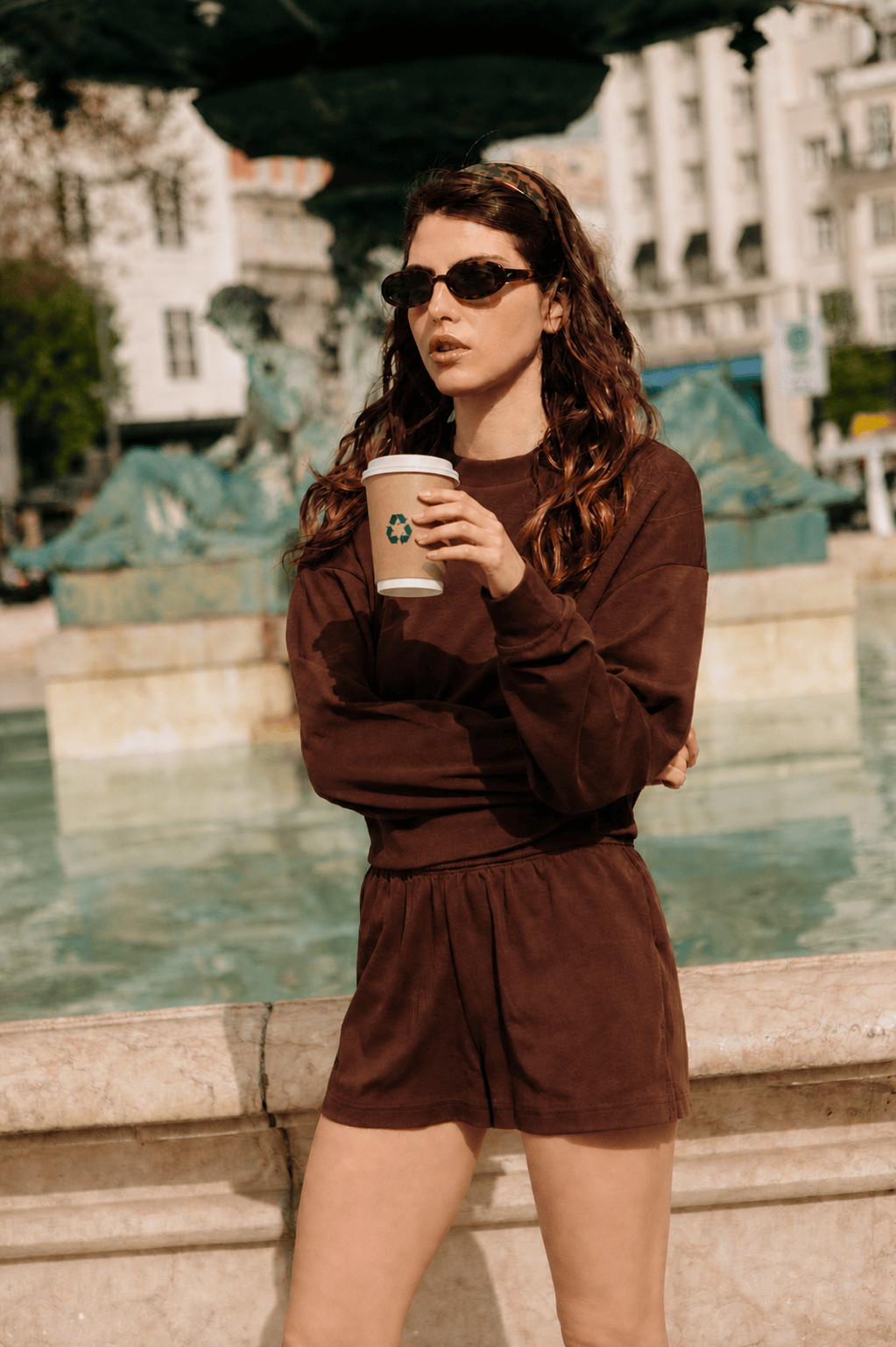 Woman in chocolate brown oversized crewneck sweatshirt and matching elastic waist cotton shorts. Premium casual loungewear set
