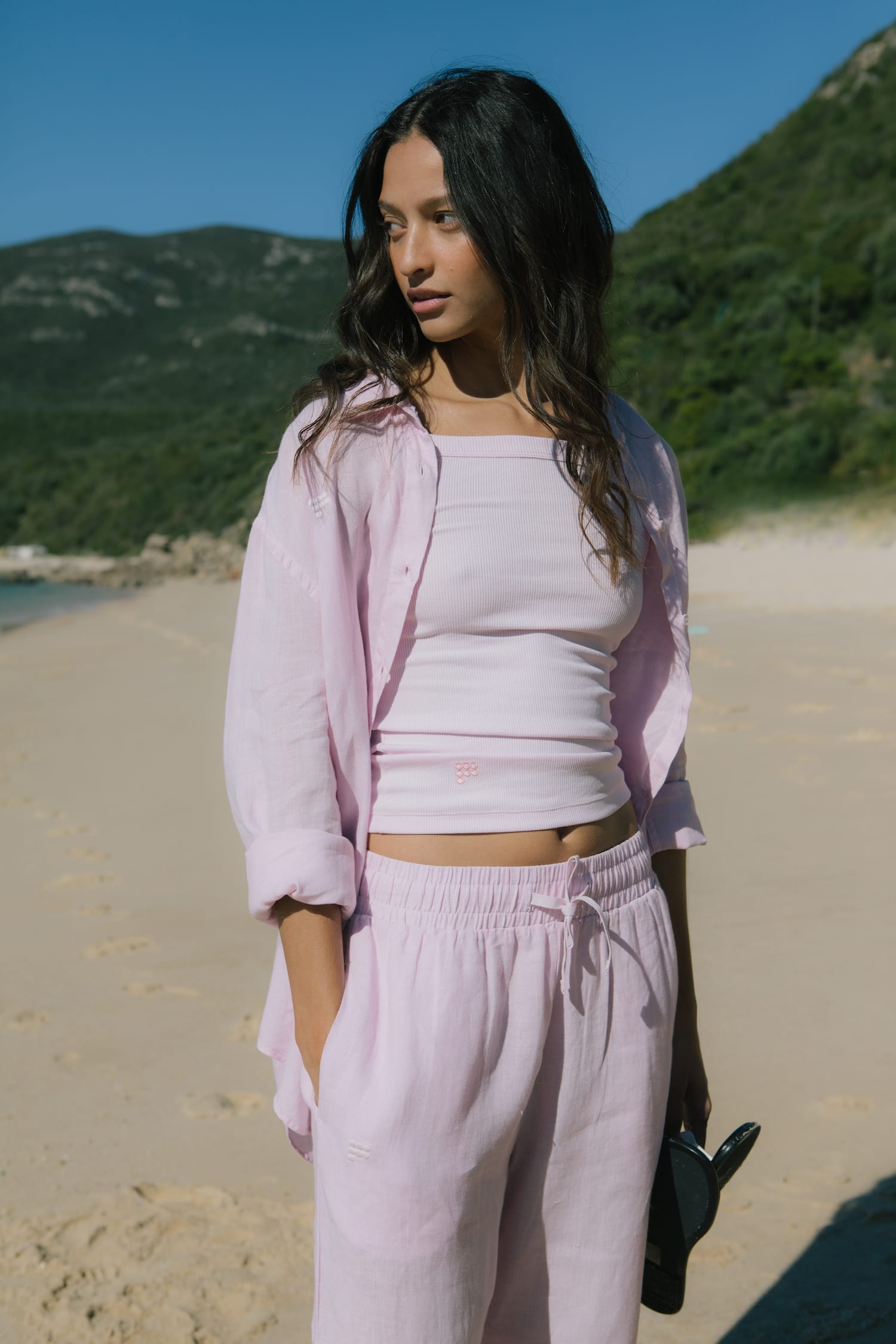 Light pink ribbed knit bandeau top, oversized linen shirt with rolled sleeves, and linen drawstring pants on model