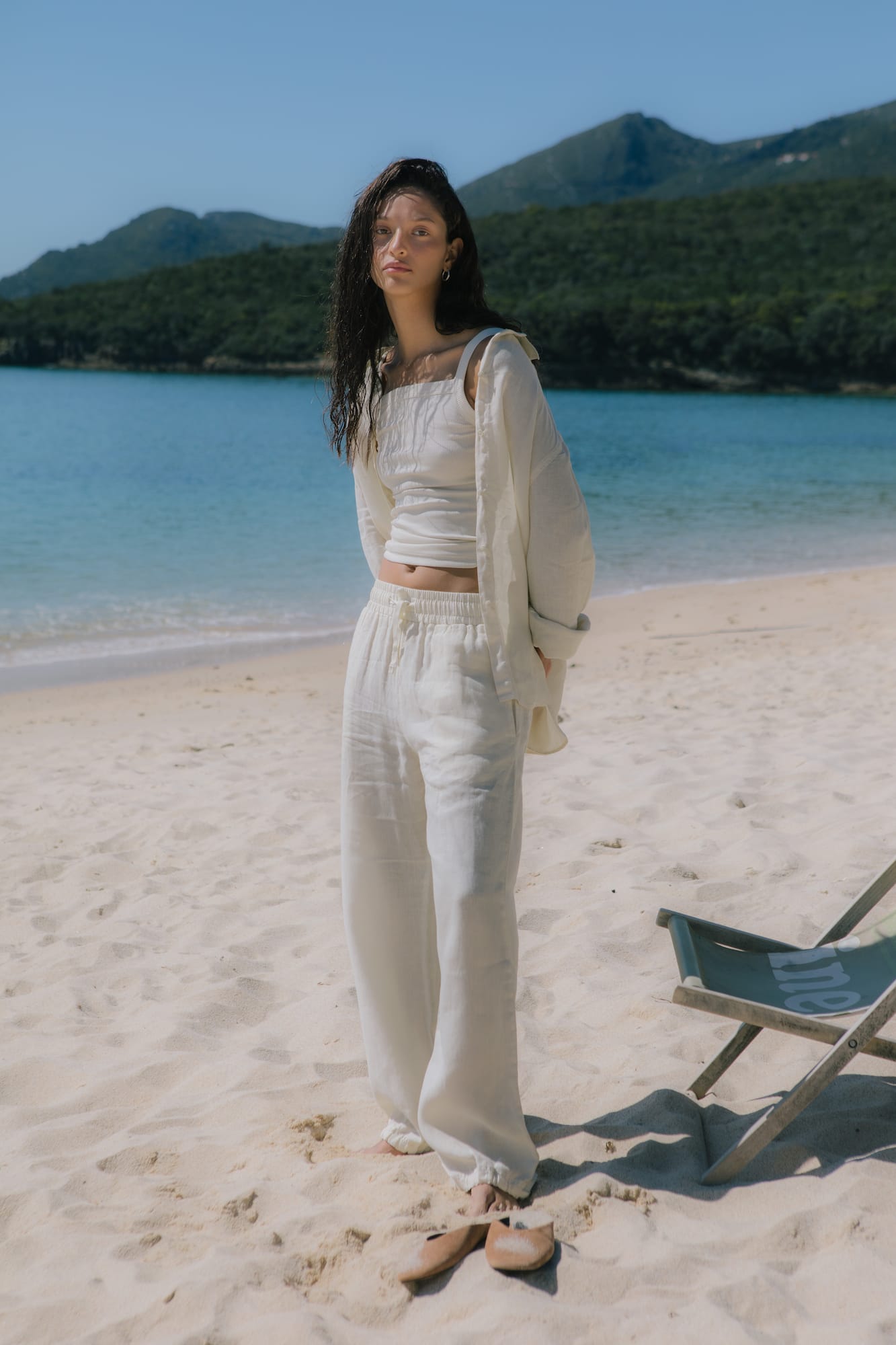 Ecru women's linen relaxed button-up shirt, ribbed square neck tank top, and wide-leg drawstring linen pants resortwear