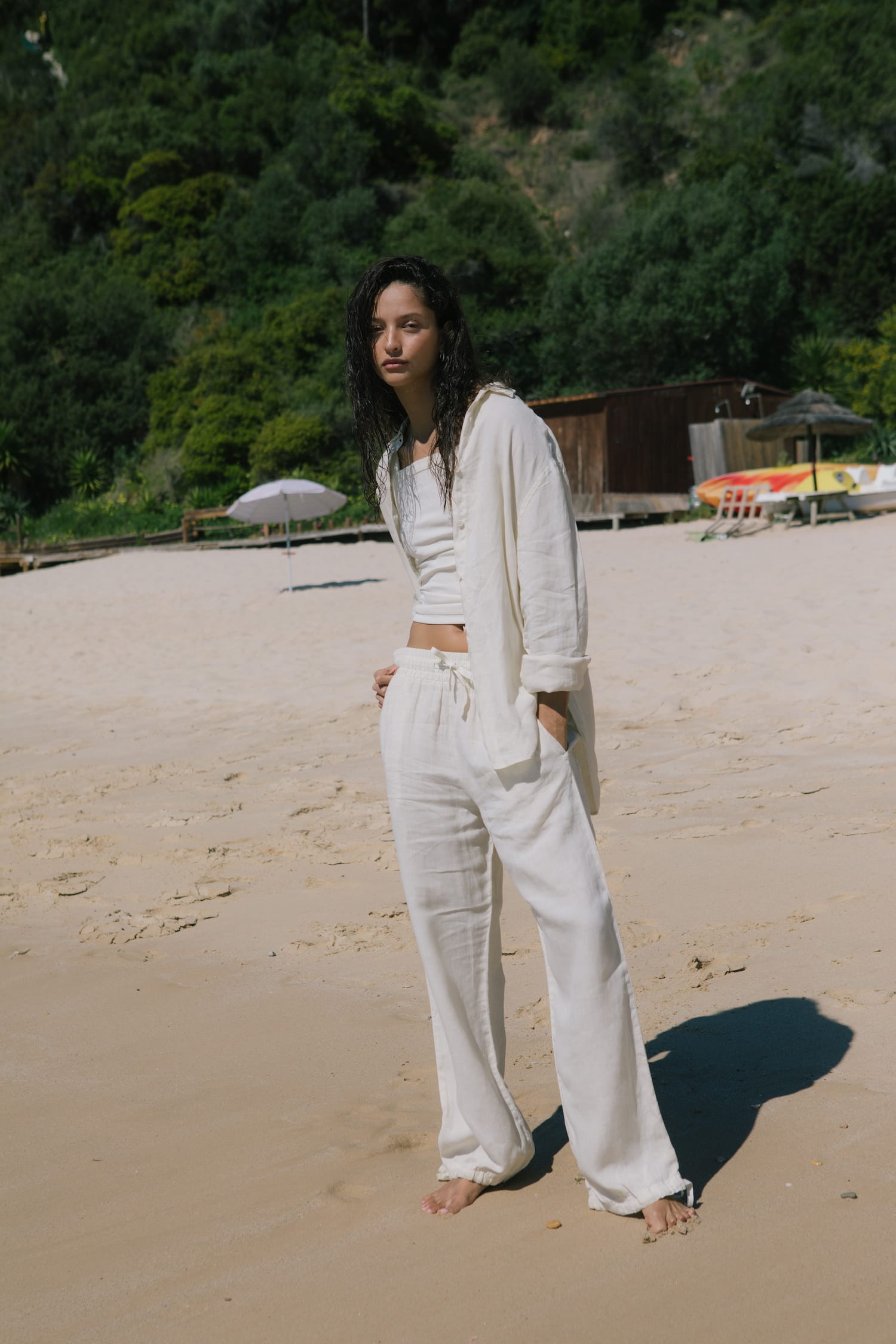 Model in cream linen square neck crop top, oversized button-up shirt, and relaxed wide-leg drawstring pants