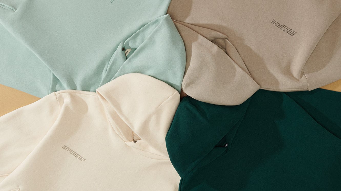 Premium cotton fleece hoodies packshot: mint, beige, cream, dark green. Soft fabric, relaxed casual fit, minimalist style