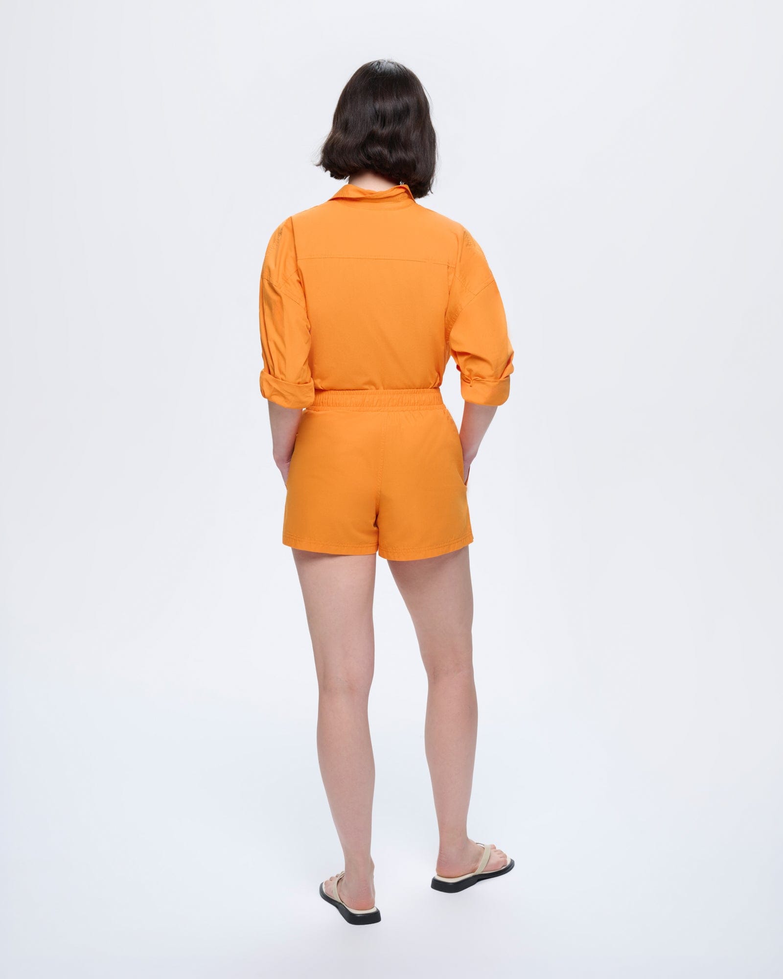 Womens Saffron Orange organic cotton poplin shorts, relaxed fit, elasticated waist, side pockets, modeled from back