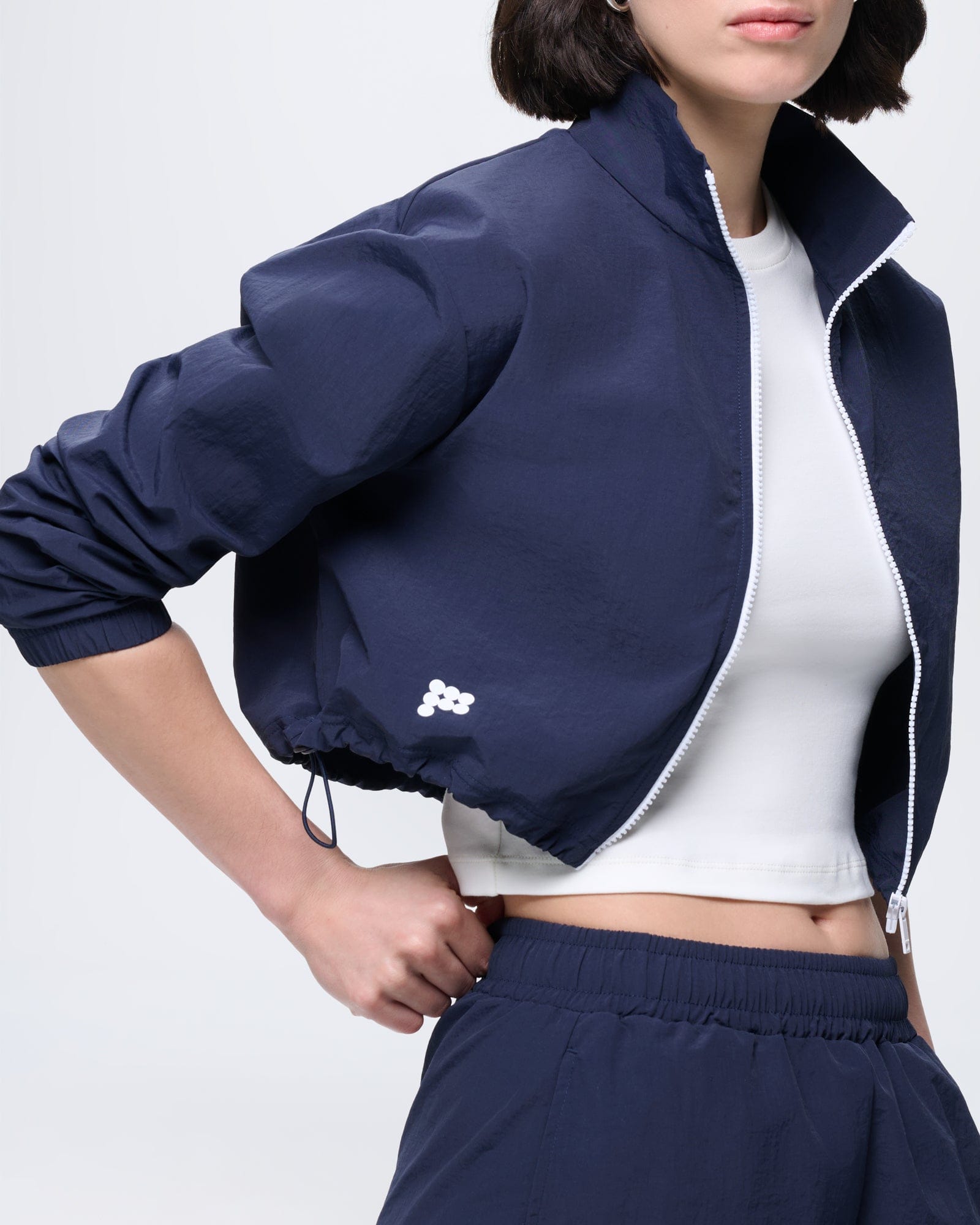 Womens recycled polyamide zip up jacket in Granite Navy. Cropped, stand collar, white zipper, drawstring hem, elastic cuffs