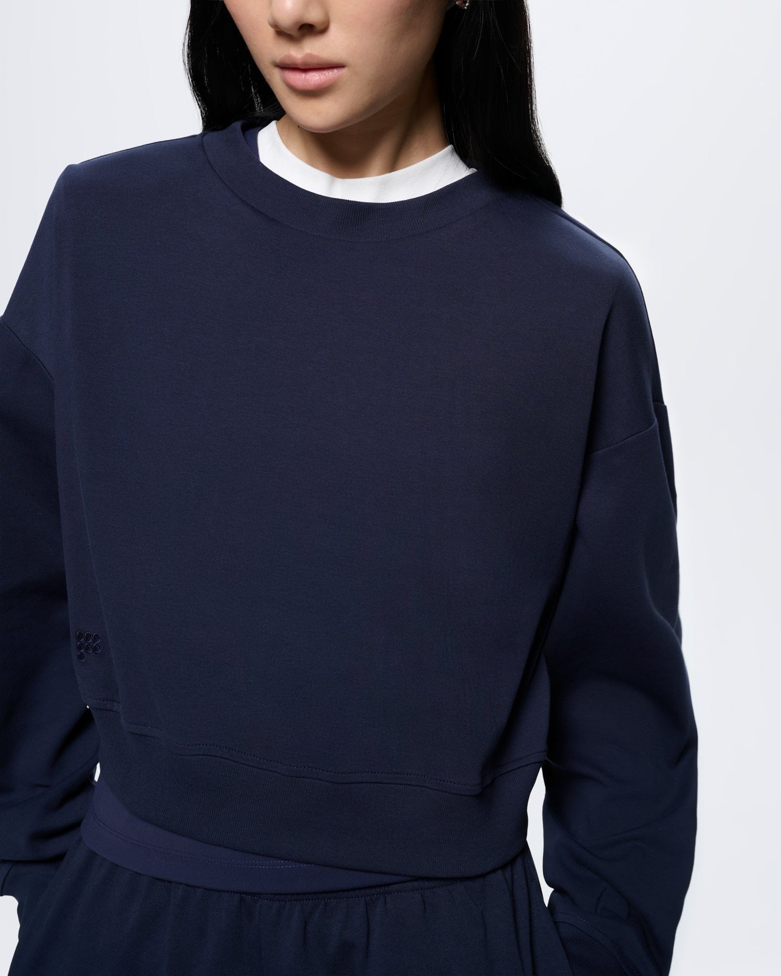 Womens Cropped Sweatshirt—Midnight Navy. Organic cotton, crew neck, long sleeves, ribbed hem, subtle tonal detail, on model