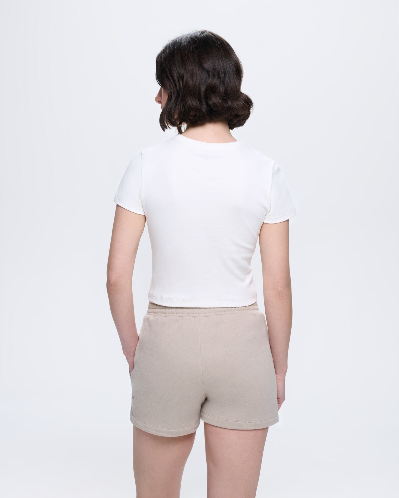 Off-white women's cropped organic cotton crew neck t-shirt, slim fit, short sleeve. Model back view