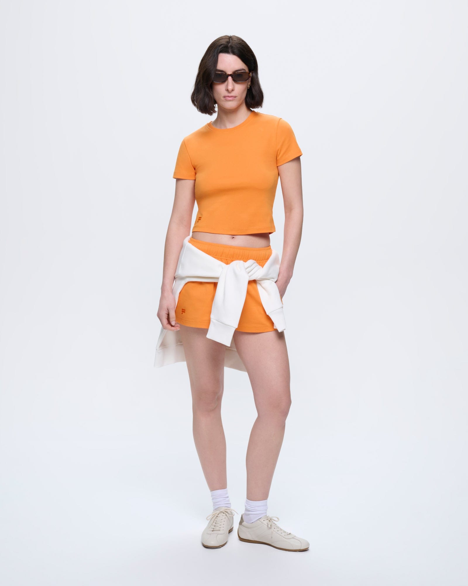 Saffron Orange Womens Cropped T-Shirt on model. Slim fit, 100% organic cotton, crew neck, short sleeves, tonal logo