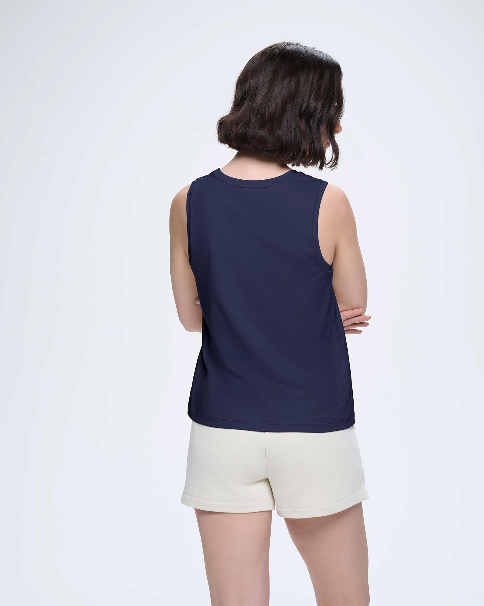 Womens ultra-soft organic cotton tank top in Midnight Navy, relaxed fit, scoop neck. Back view on model