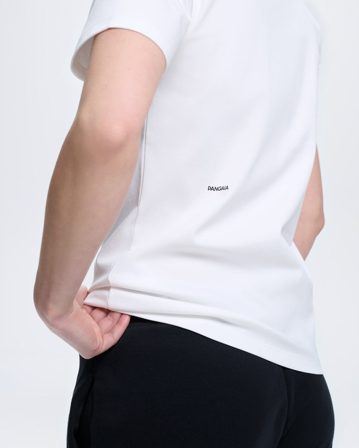 White PANGAIA short sleeve crew neck t-shirt, smooth premium fabric, relaxed fit, worn with black trousers