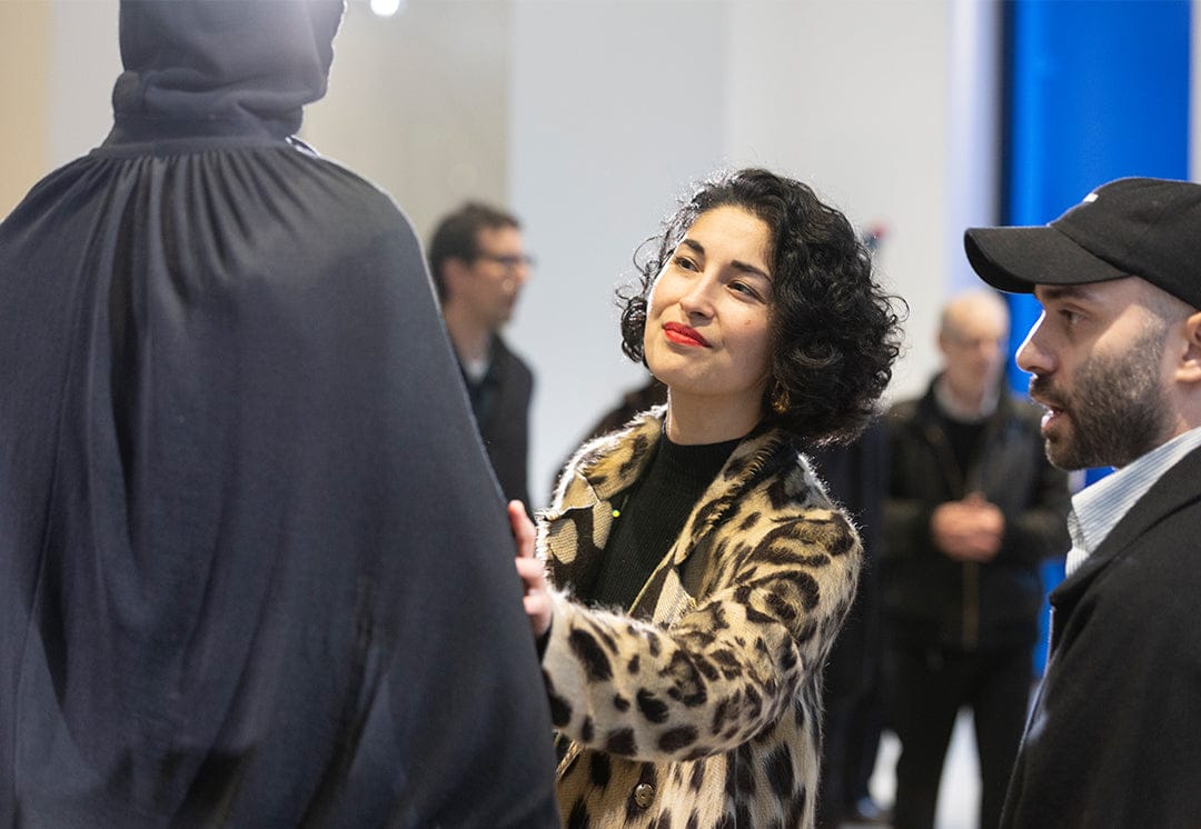 Woman wearing a stylish leopard print fuzzy textured coat over a black ribbed knit top