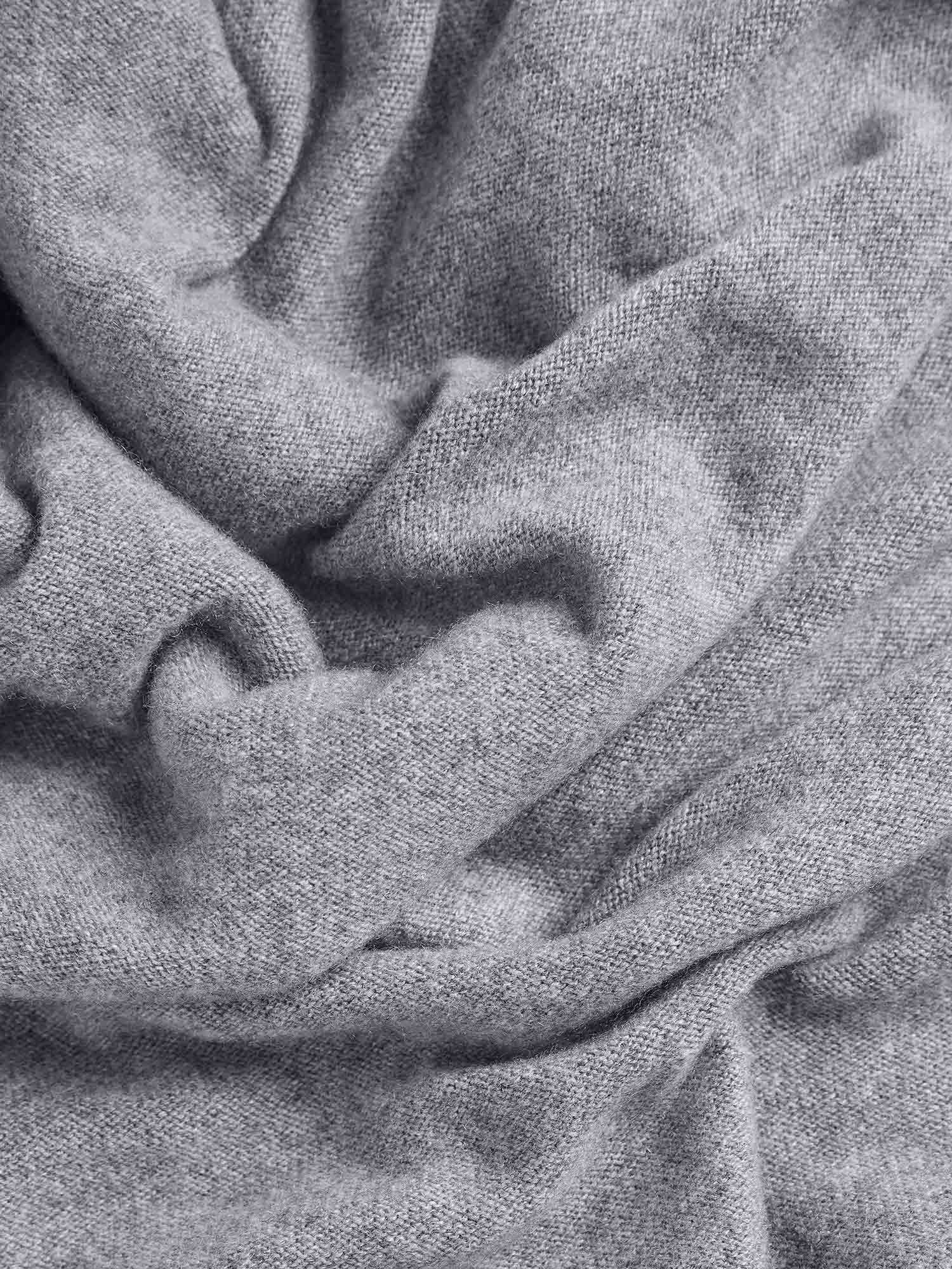Soft light grey fine knit cashmere fabric, draped texture detail packshot for luxury garments